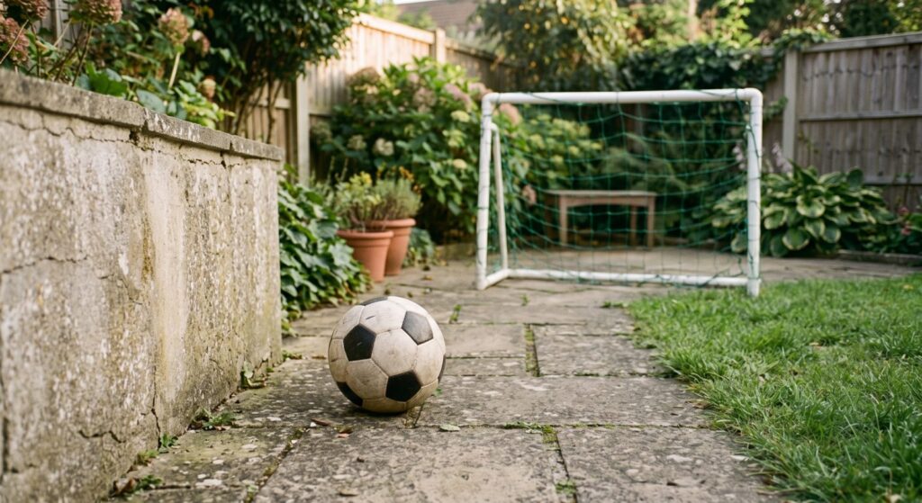 Soccer ball on a backyard patio in front of a small goal